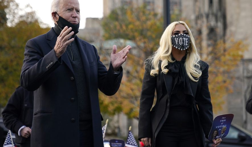 Democratic presidential candidate former Vice President Joe Biden stands with Lady Gaga, right, Monday, Nov. 2, 2020, in Pittsburgh, Pa. (AP Photo/Andrew Harnik)