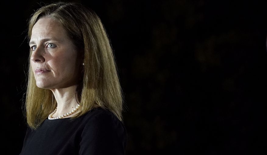 In this Oct. 26, 2020, file photo Amy Coney Barrett, listens as President Donald Trump speaks before Supreme Court Justice Clarence Thomas administers the Constitutional Oath to Barrett on the South Lawn of the White House in Washington, after she was confirmed by the Senate. (AP Photo/Patrick Semansky, File)