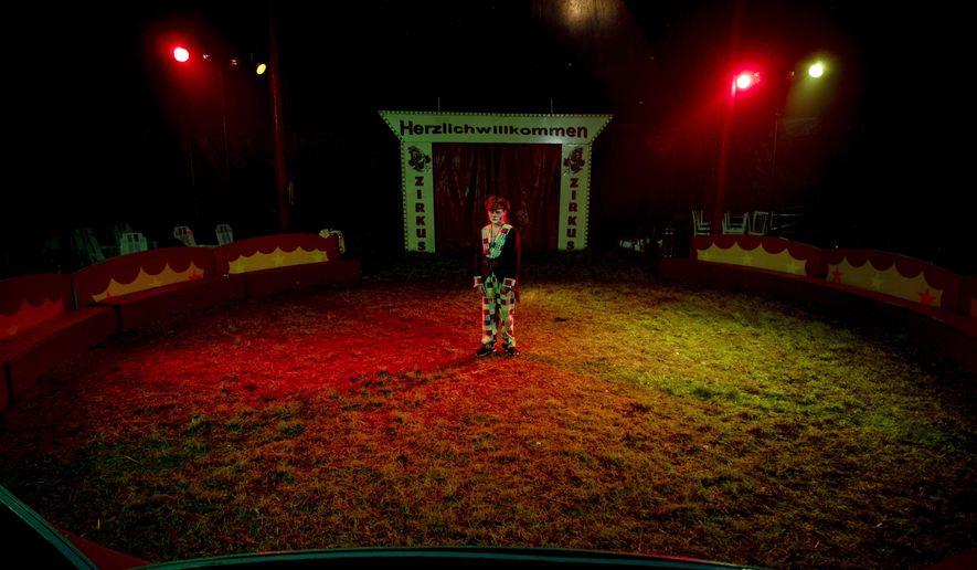Eleven-year-old clown Angie stands in the circus ring after the last performance of small circus Delmonde in Frankfurt, Germany, Sunday, Nov. 1, 2020. As Germany embarks Monday on a four-week partial lockdown, the family-run circus joins theaters, cinemas, sports facilities, restaurants and bars across the country in shutting down and hoping for the best. (AP Photo/Michael Probst)