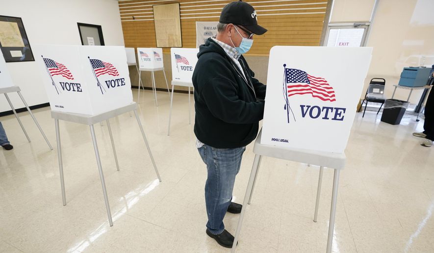 FILE - In this Oct. 20, 2020 file photo, Kelly Wingfield, of Urbandale, Iowa, fills out his ballot during early voting in the general election, in Adel, Iowa. County election boards have started counting a record number of absentee ballots in Iowa, racing toward a Tuesday night, Nov. 3 deadline to have those votes tabulated. Nearly 956,000 people had sent in their ballots by mail, dropped them off at auditor's offices or voted early in person as of Monday, morning Nov. 2. (AP Photo/Charlie Neibergall, File)
