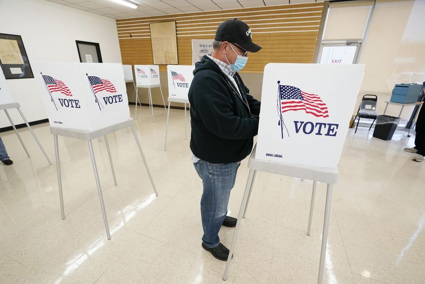 FILE - In this Oct. 20, 2020 file photo, Kelly Wingfield, of Urbandale, Iowa, fills out his ballot during early voting in the general election, in Adel, Iowa. County election boards have started counting a record number of absentee ballots in Iowa, racing toward a Tuesday night, Nov. 3 deadline to have those votes tabulated. Nearly 956,000 people had sent in their ballots by mail, dropped them off at auditor's offices or voted early in person as of Monday, morning Nov. 2. (AP Photo/Charlie Neibergall, File)