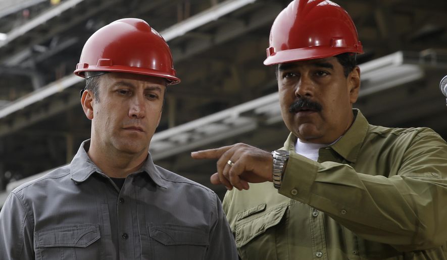 FILE - In this May 19, 2018 file photo, Venezuela&#39;s President Nicolas Maduro, right, and then Vice President Tareck El Aissami tour the construction site of La Rinconada baseball stadium on the outskirts of Caracas, Venezuela. The prosecution of El Aissami, Venezuela’s Oil Minister, for violating U.S. sanctions has run into another snag after a federal judge on Monday, Nov. 2, 2020, allowed one of his co-defendants to withdraw a guilty plea over allegations U.S. attorneys withheld evidence in the case. (AP Photo/Ricardo Mazalan, File)