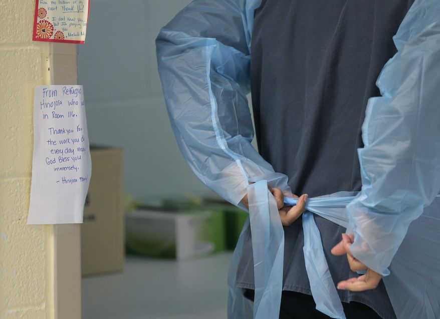FILE - In this July 27, 2020, file photo, notes to medical personnel are hung in an area as they prepare to ender a COVID-19 unit at Starr County Memorial Hospital in Rio Grande City, Texas. As the coronavirus pandemic surges across the nation and infections and hospitalizations rise, medical administrators are scrambling to find enough nursing help — especially in rural areas and at small hospitals. (AP Photo/Eric Gay, File)