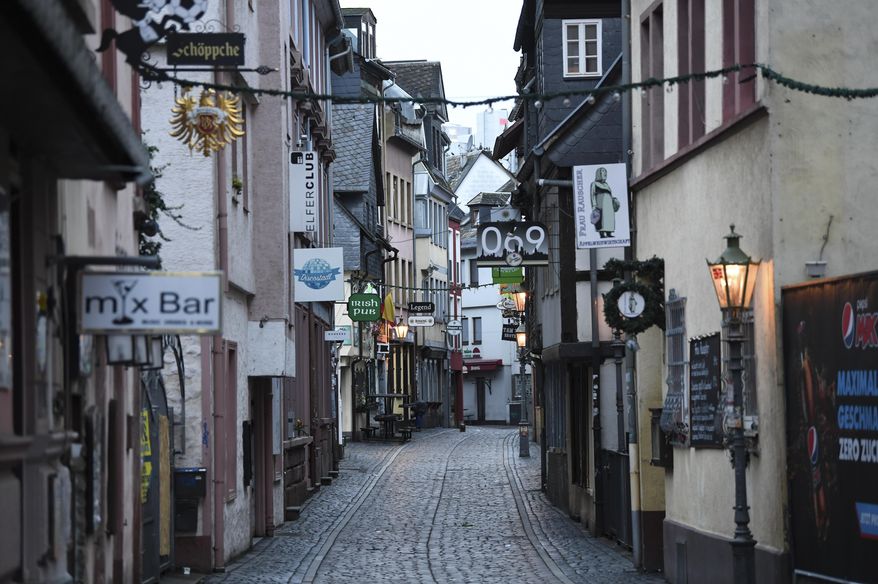 The Klappergasse in Frankfurt's pub district of Alt-Sachsenhausen is deserted in Frankfurt, Germany, Monday, Nov.2, 2020. A four-week partial lockdown has begun all over Germany to slow down the spread of the corona virus.(Arne Dedert/dpa via AP)