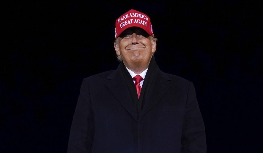 President Donald Trump smiles at supporters after a campaign rally at Gerald R. Ford International Airport, early Tuesday, Nov. 3, 2020, in Grand Rapids, Mich. (AP Photo/Evan Vucci)