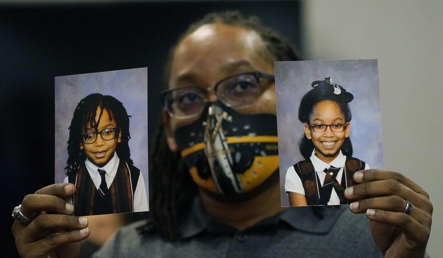 In this Tuesday, Oct. 27, 2020, file photo, Sheldon Smith, center, holds the photographs of his children Deshawn Smith, 11, left, and Trinitee Smith, 13, both suffering from sickle cell anemia, during an Initiative 65 rally in Ridgeland, Miss. Smith and his wife Keishawna Smith believe their children would benefit from medical marijuana treatment for pain management. Initiative 65 would amend the Mississippi Constitution to allow the prescription by a doctor of up to 5 ounces (142 grams) of marijuana per month for people who suffer from more than 20 medical conditions. The state lawmakers are offering a more restrictive measure as an alternative. (AP Photo/Rogelio V. Solis, File)