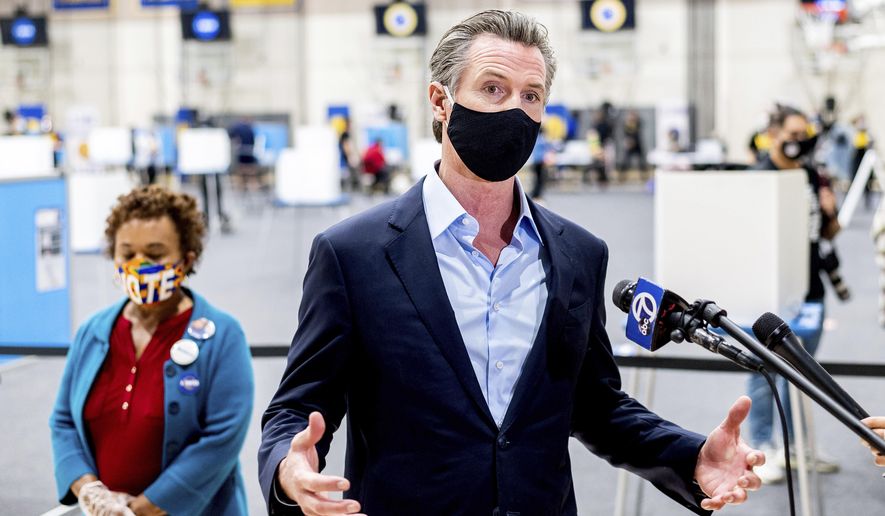 Gov. Gavin Newsom discusses the 2020 election while visiting the Golden State Warriors training facility, which is serving as a polling location, on Tuesday, Nov. 3, 2020, in Oakland, Calif. At left is Rep. Barbara Lee, D-Calif. (AP Photo/Noah Berger)