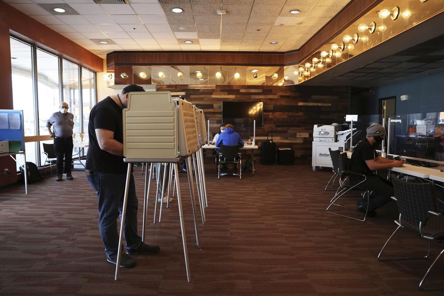 A man fills out his ballot after registering to vote at Vanguard Church in Colorado Springs, Colo., Tuesday, Nov. 3, 2020. The church served as a location where voters could register, drop off completed ballots or fill out a ballot in person. (Forrest Czarnecki/The Gazette via AP)