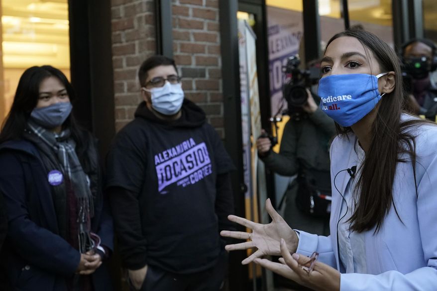 U.S. Rep. Alexandria Ocasio-Cortez, D-N.Y., right, speaks to members of her staff and volunteers who helped with her campaign and getting out the vote, Tuesday, Nov. 3, 2020, outside her office in the Bronx borough of New York. (AP Photo/Kathy Willens)