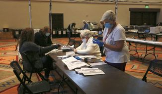 Election workers sort electronically submitted ballots at the Santa Fe Convention Center on Election Day, Tuesday, Nov. 3, 2020, in Santa Fe, N.M.  (AP Photo/Cedar Attanasio)