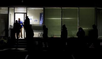 People stand in line at the Hamilton County Board of Elections as they wait to vote, Tuesday, Nov. 3, 2020, in Norwood, Ohio. (AP Photo/Aaron Doster)
