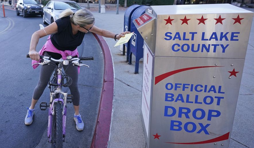 Debbie Sorensen inserts her ballot into a drops box Monday, Nov. 2, 2020, in Salt Lake City. (AP Photo/Rick Bowmer)