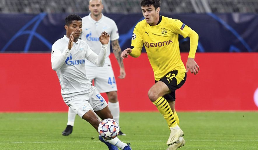 Dortmund's Giovanni Reyna, right, and Zenit's Wilmar Barrios, left, challenge for the ball during the Champions League group F soccer match between Borussia Dortmund and Zenit Saint Petersburg in Dortmund, Germany, Wednesday, Oct. 28, 2020. (Bernd Thissen/Pool via AP)