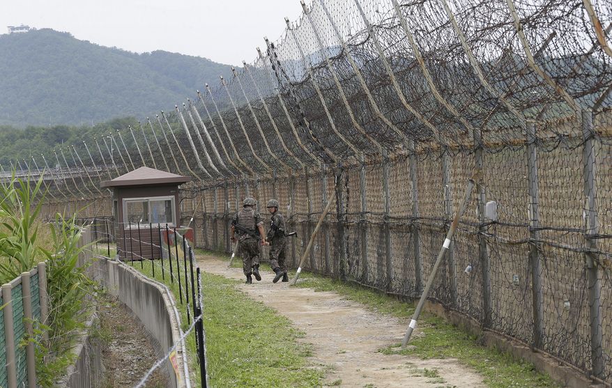 FILE - In this June 14, 2019, file photo, South Korean army soldiers patrol while hikers visit the DMZ Peace Trail in the demilitarized zone in Goseong, South Korea. South Korean troops were engaged in an operation near the heavily fortified border with North Korea on Wednesday, Nov. 4, 2020, after detecting "unidentified personnel" there, the South's military said. (AP Photo/Ahn Young-joon, File)