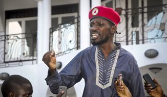 FILE - In this Thursday, May 2, 2019 file photo, Ugandan pop star and opposition politician Bobi Wine, whose real name is Kyagulanyi Ssentamu, greets his followers as he arrives home after being released from prison on bail in Kampala, Uganda. Police on Tuesday, Nov. 3, 2020 again arrested Bobi Wine, dragging him from his car and putting him in a police van, just after he was successfully certified as a candidate in next year&#39;s election. (AP Photo/Ronald Kabuubi, File)