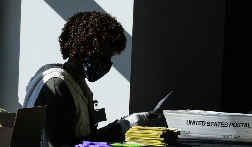 An election worker counts ballots at State Farm Arena on Wednesday, Nov. 4, 2020, in Atlanta. (AP Photo/Brynn Anderson)