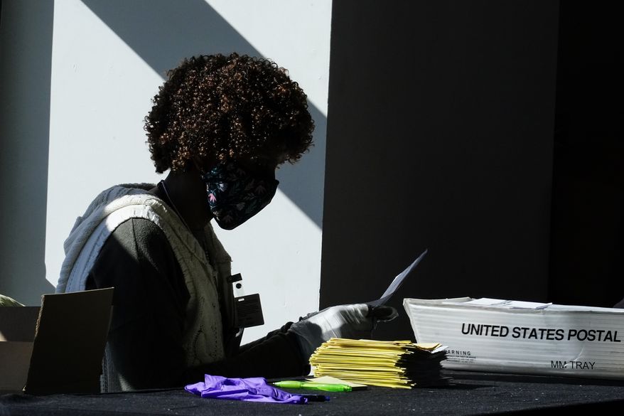 An election worker counts ballots at State Farm Arena on Wednesday, Nov. 4, 2020, in Atlanta. (AP Photo/Brynn Anderson)