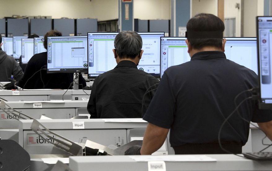 Workers count votes on election night at the Los Angele County Registrar's Tally Operations Center in Downey, Calif., Tuesday, Nov. 3, 2020. (Keith Birmingham/The Orange County Register via AP)