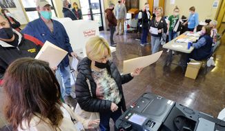Voter Kari Ackerman, center, casts her ballot with help from poll worker Brenda Anderson, left, at the Girard Borough Building on Tuesday, Nov. 3, 2020, in Erie, Pa. (Greg Wohlford/Erie Times-News via AP) ** FILE **