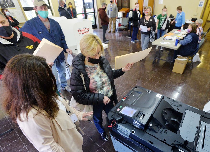 Voter Kari Ackerman, center, casts her ballot with help from poll worker Brenda Anderson, left, at the Girard Borough Building on Tuesday, Nov. 3, 2020, in Erie, Pa. (Greg Wohlford/Erie Times-News via AP) ** FILE **