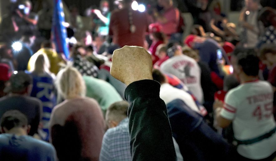 President Donald Trump supporters kneel in prayer as they rally, Wednesday, Nov. 4, 2020, outside the Maricopa County Recorders Office in Phoenix. (AP Photo/Matt York)