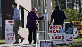 Voters are assisted at a polling location at the South Regional Library in Durham, N.C., Tuesday, Nov. 3, 2020. (AP Photo/Gerry Broome)