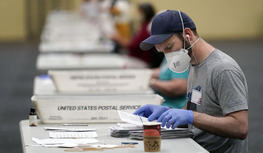 Workers prepare mail-in ballots for counting, Wednesday, Nov. 4, 2020, at the convention center in Lancaster, Pa., following Tuesday&#39;s election. (AP Photo/Julio Cortez)