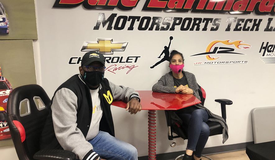 Urban Youth Racing School founder Anthony Martin, left, and his wife Michelle Martin pose for a photo at the school, Friday, Oct. 30, 2020, in Philadelphia. The school has made it its mission to introduce inner-city youngsters, most of them black, to the motorsports world. (AP Photo/Dan Gelston)