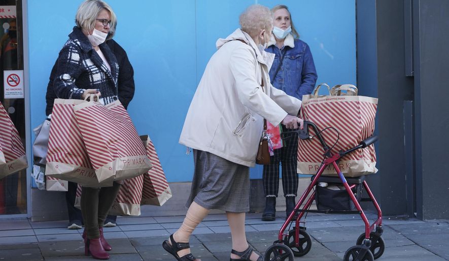 Shoppers leave a store in Northumberland Street, ahead of a national lockdown for England which begins on Thursday, in Newcastle, England, Wednesday, Nov. 4, 2020. A second lockdown in England is set to come into force on Thursday. It's a big blow to businesses that sweeps away any hopes that the British economy might have recovered by the end of this year a large proportion of the near 25% drop endured in the spring. (Owen Humphreys/PA via AP)