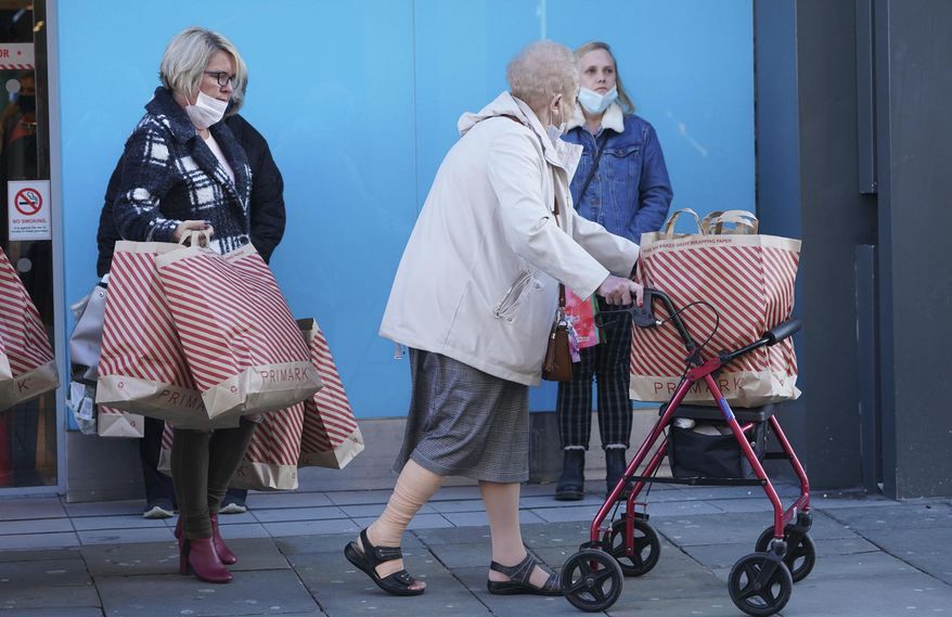 Shoppers leave a store in Northumberland Street, ahead of a national lockdown for England which begins on Thursday, in Newcastle, England, Wednesday, Nov. 4, 2020. A second lockdown in England is set to come into force on Thursday. It's a big blow to businesses that sweeps away any hopes that the British economy might have recovered by the end of this year a large proportion of the near 25% drop endured in the spring. (Owen Humphreys/PA via AP)