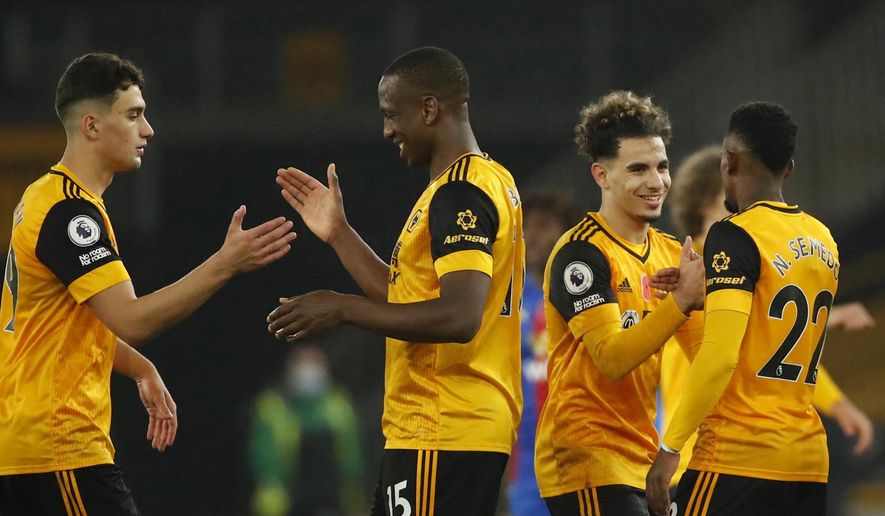 Wolverhampton Wanderers&#39; players shake hands at the end of the English Premier League soccer match between Wolverhampton Wanderers and Crystal Palace at the Molineux Stadium in Wolverhampton, England, Friday, Oct, 30, 2020. (Andrew Boyers/Pool via AP)