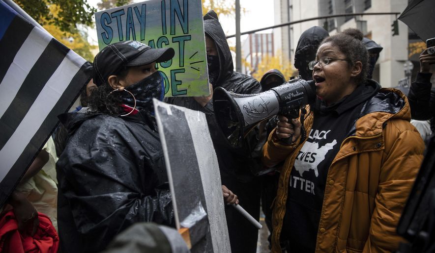 Back the Blue police supporters, left, stand next to Black Lives Matter protesters calling for defunding the police, Thursday, Nov. 5, 2020, in Portland, Ore. (AP Photo/Paula Bronstein)