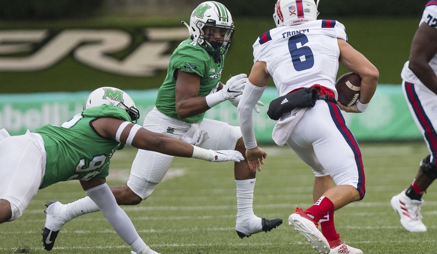 Marshall defensive tackle Jamare Edwards (99) and linebacker Tavante Beckett (4) attempt to bring down Florida Atlantic quarterback Nick Tronti (6) during an NCAA college football game on Saturday, Oct. 24, 2020, at Joan C. Edwards Stadium Huntington, W.Va. (Sholten Singer/The Herald-Dispatch via AP)