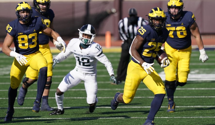 Michigan running back Hassan Haskins (25) rushes during the second half of an NCAA college football game against Michigan State, Saturday, Oct. 31, 2020, in Ann Arbor, Mich. (AP Photo/Carlos Osorio)