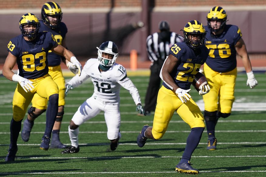 Michigan running back Hassan Haskins (25) rushes during the second half of an NCAA college football game against Michigan State, Saturday, Oct. 31, 2020, in Ann Arbor, Mich. (AP Photo/Carlos Osorio)