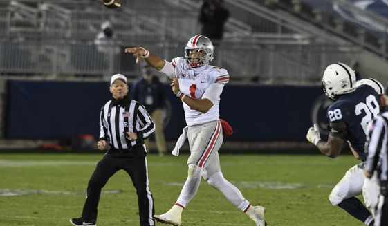 Ohio State quarterback Justin Fields (1) passes while being chased by Penn State defensive end Jayson Oweh (28) in the fourth quarter of an NCAA college football game in State College, Pa., Saturday, Oct. 31, 2020. Ohio State won 38-25. (AP Photo/Barry Reeger)
