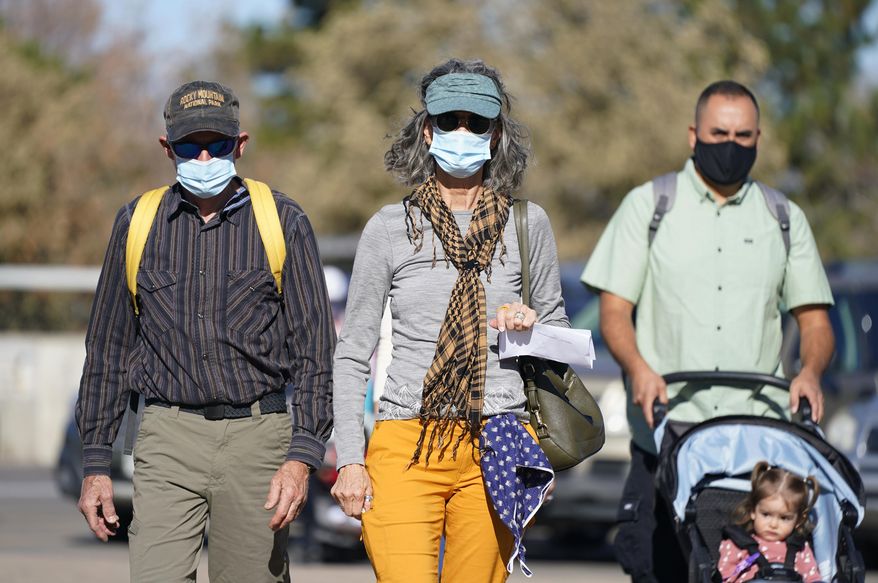 Visitor comply with the face mask mandate due to the coronavirus as they enter the Denver Zoo early Thursday, Nov. 5, 2020, in Denver. (AP Photo/David Zalubowski)