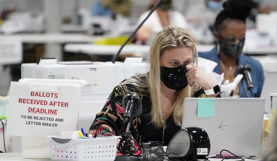 Workers at the Gwinnett County Voter Registration and Elections Headquarters, Friday, Nov. 6, 2020, in Lawrenceville, near Atlanta. (AP Photo/John Bazemore) **FILE**