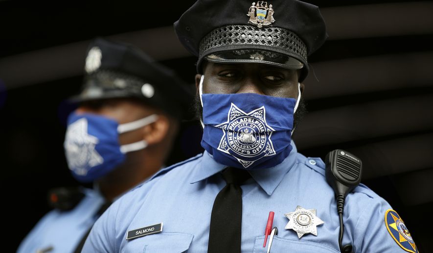Police officers stand outside the Pennsylvania Convention Center where votes are being counted, Friday, Nov. 6, 2020, in Philadelphia. (AP Photo/Rebecca Blackwell)