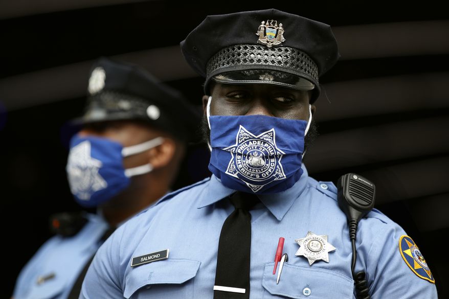 Police officers stand outside the Pennsylvania Convention Center where votes are being counted, Friday, Nov. 6, 2020, in Philadelphia. (AP Photo/Rebecca Blackwell)