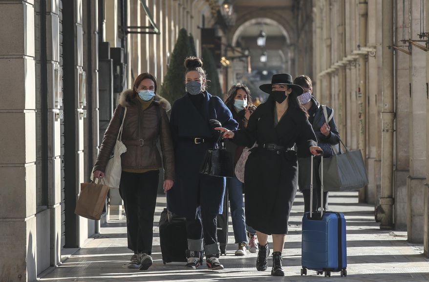 Women wearing face masks as a precaution against the coronavirus walks at the rue Rivoli in Paris, Friday, Nov. 6, 2020. The French government is supplying quick virus tests to nursing homes around the country, amid sharply rising numbers of virus infections and deaths in care homes in recent weeks. (AP Photos/Michel Euler)