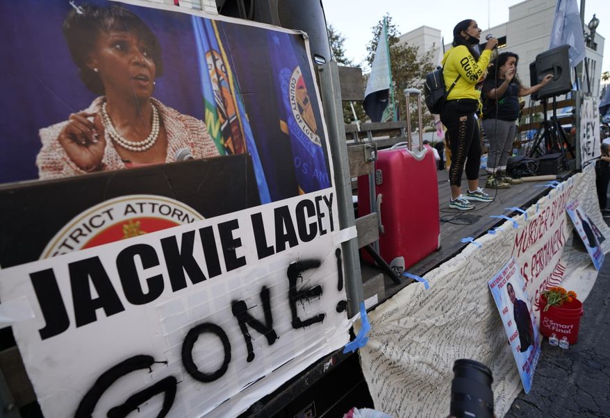 Protesters gather outside the gated Hall of Justice to protest Los Angeles District Attorney Jackie Lacey in downtown Los Angeles, Wednesday, Nov. 4, 2020. Former San Francisco District Attorney George Gascon led two-term incumbent Lacey with 54% of more than 2.7 million votes counted by Wednesday. (AP Photo/Damian Dovarganes)
