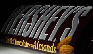 FILE - This April 21, 2020 file photo shows a Hershey&#39;s chocolate bar with almonds in Philadelphia.  Hershey says its Halloween candy sales were up slightly this year despite lower enthusiasm for trick-or-treating amid the pandemic. Michele Buck _ chairman, president and CEO of The Hershey Co. _ said Friday, Nov. 6, 2020,  that earlier shipments of Halloween candy to stores helped boost sales.  (AP Photo/Matt Rourke, File)