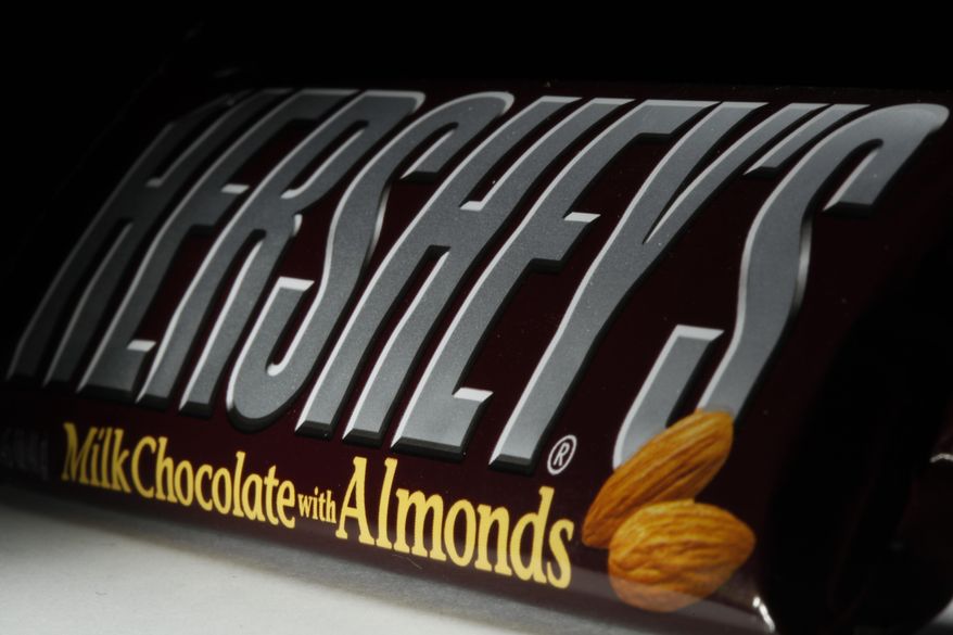 This April 21, 2020 file photo shows a Hershey&#x27;s chocolate bar with almonds in Philadelphia.  Hershey says its Halloween candy sales were up slightly this year despite lower enthusiasm for trick-or-treating amid the pandemic. Michele Buck _ chairman, president and CEO of The Hershey Co. _ said Friday, Nov. 6, 2020,  that earlier shipments of Halloween candy to stores helped boost sales.  (AP Photo/Matt Rourke, File)