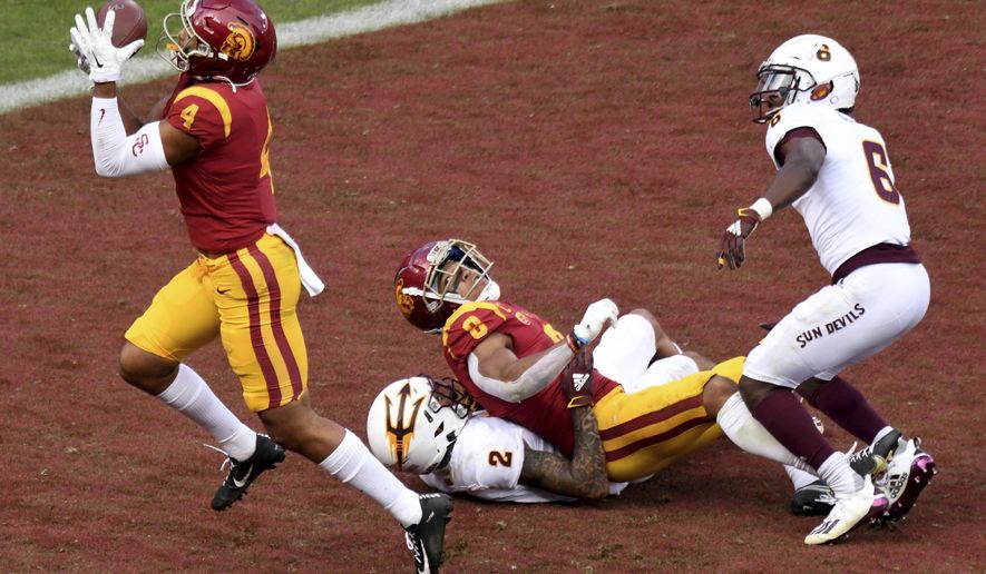 Arizona State wide receiver Bru McCoy (4) catches a pass for a touchdown that was tipped by teammate wide receiver Amon-Ra St. Brown (8) as Arizona State defensive back DeAndre Pierce (2) and defensive back Timarcus Davis (6) during the second half of an NCAA college football game Los Angeles, Saturday, Nov. 7, 2020. (Keith Birmingham/The Orange County Register via AP)