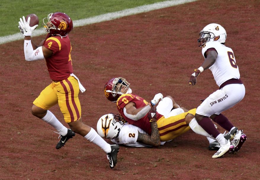 Arizona State wide receiver Bru McCoy (4) catches a pass for a touchdown that was tipped by teammate wide receiver Amon-Ra St. Brown (8) as Arizona State defensive back DeAndre Pierce (2) and defensive back Timarcus Davis (6) during the second half of an NCAA college football game Los Angeles, Saturday, Nov. 7, 2020. (Keith Birmingham/The Orange County Register via AP)