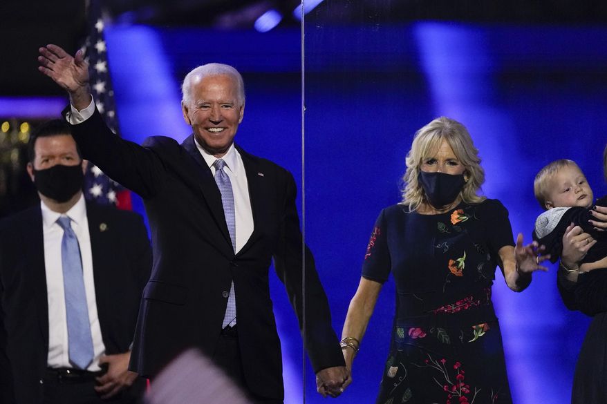 President-elect Joe Biden stands on stage with his wife Jill, Saturday, Nov. 7, 2020, in Wilmington, Del. (AP Photo/Andrew Harnik)