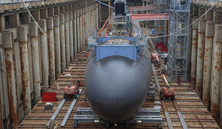 FILE- In this July 30, 2015, file photo, shipyard workers work at General Dynamics Electric Boat in Groton, Conn., prepare a submarine for float-off. Connecticut and Rhode Island officials are celebrating a new submarine contract for General Dynamics Electric Boat as a major economic win for the region&#39;s economy. The  $9.47 billion contract with the U.S. Navy, which was announced Friday, Nov. 6, 2020, is for construction and testing of the first two Columbia-class submarines.  AP Photo/Jessica Hill, File)
