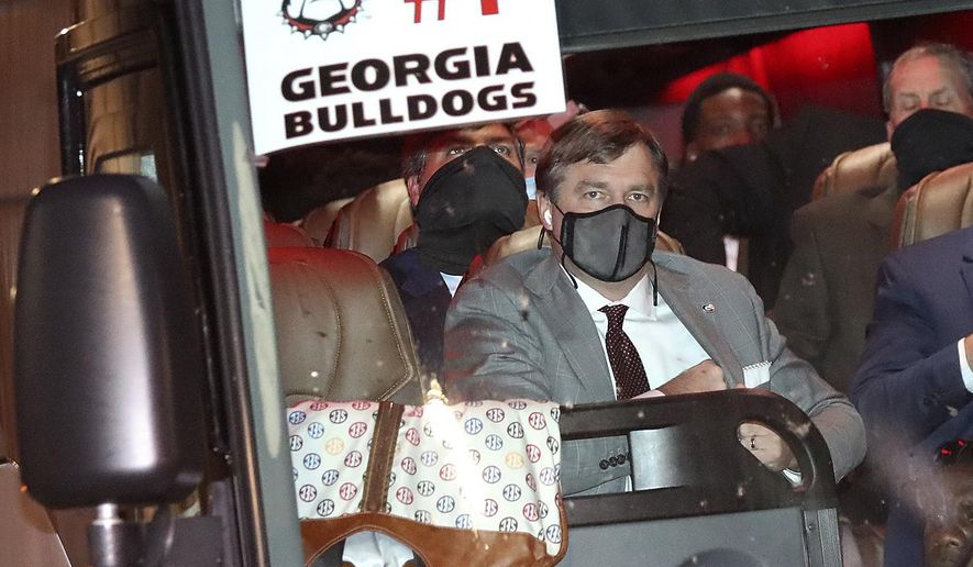Georgia coach Kirby Smart wears a mask on one the five buses carrying the football team arrives at a hotel Friday night, Nov. 6, 2020, in Jacksonville, Fla., for Saturday's Georgia-Florida NCAA college football game. (Curtis Compton/Atlanta Journal-Constitution via AP)