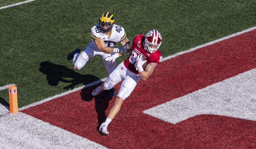 Indiana tight end Peyton Hendershot (86) crosses into the end zone to score ahead of Michigan linebacker Ben VanSumeren (40) during the first half of an NCAA college football game Saturday, Nov. 7, 2020, in Bloomington, Ind. (AP Photo/Doug McSchooler)